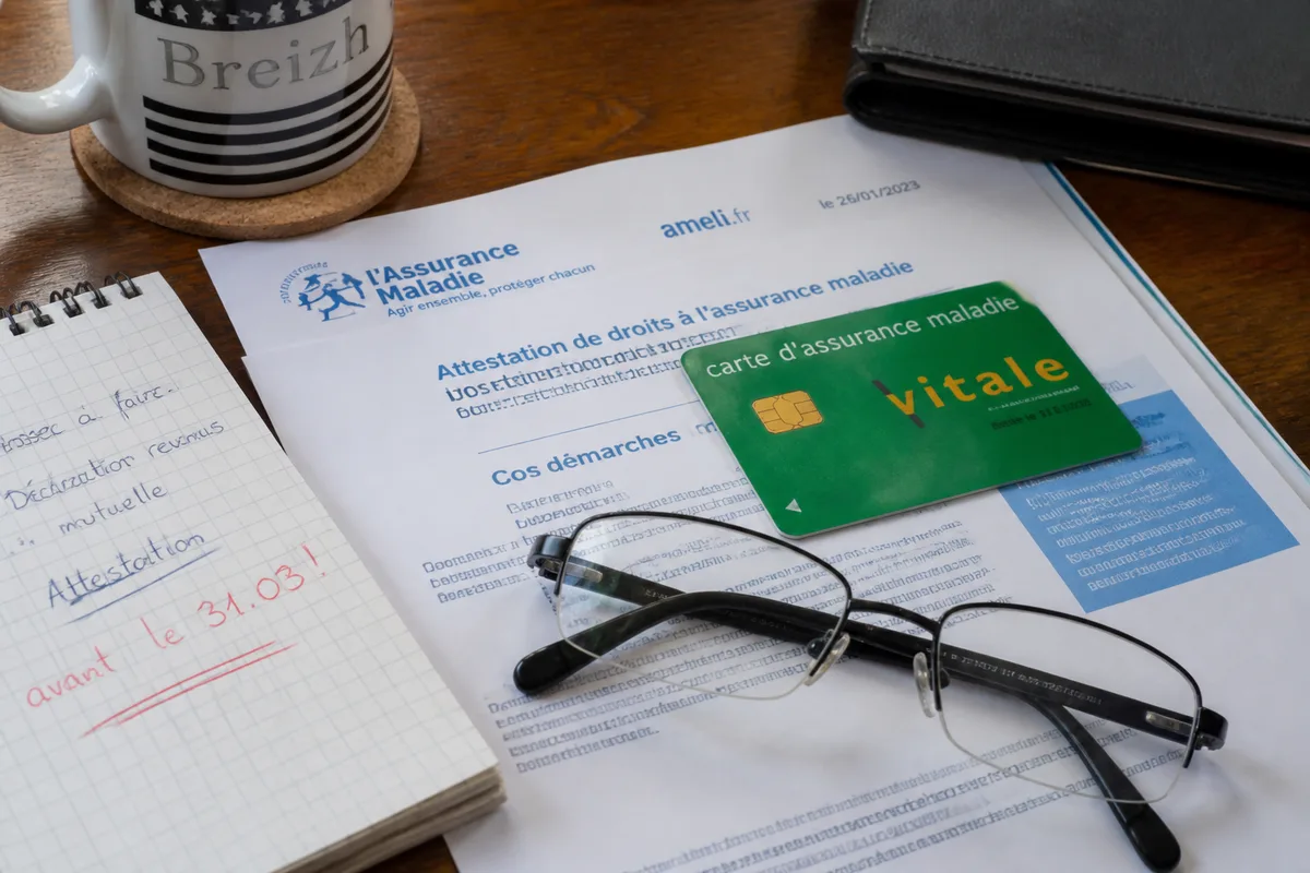Dossier de maintien d’une complémentaire santé après un départ à la retraite, avec courrier d’assureur et carte de santé sur une table